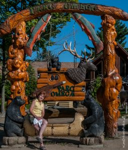 Crystine avec une vue globale de l'enseigne du parc devant le magasin général.